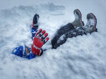 High angle view of boy lying on snow