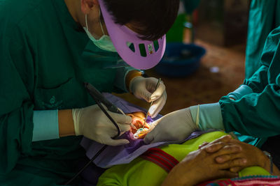 Male dentist operating patient in hospital