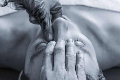 Close-up of cropped hands giving massage to man