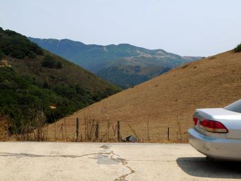 Road by mountains against clear sky