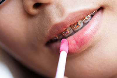 Cropped image of woman applying lipstick