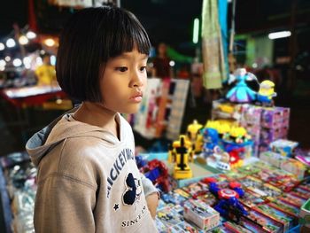 Girl looking away by toys in store for sale