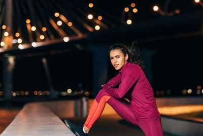 Portrait of smiling woman sitting at night