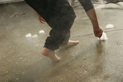 Low section of person playing with ice at home