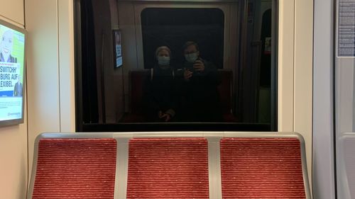 Reflection of people on train window