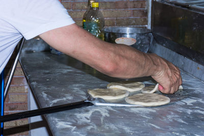 Midsection of man preparing food in kitchen