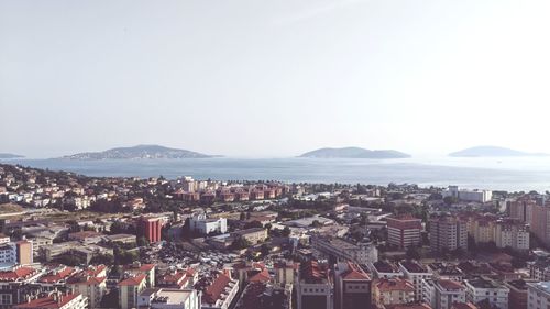 High angle view of townscape by sea against clear sky