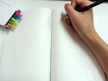 Midsection of woman reading book on table