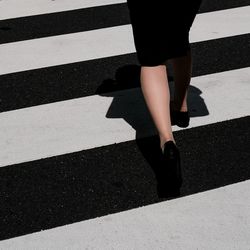 Low section of woman walking on road