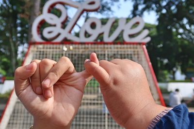 Close-up of two kids giving pinky promise