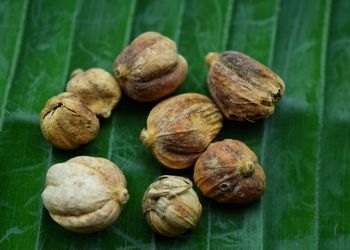 Some white and round cardamom on green banana leaves