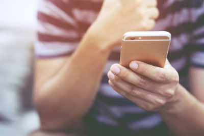 Midsection of man using mobile phone