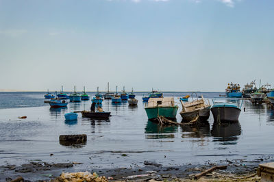 Boats moored in sea against clear sky