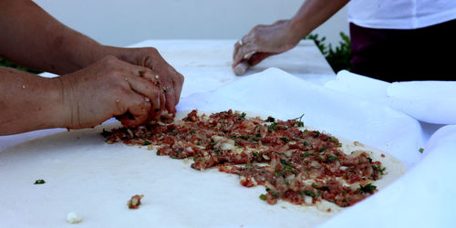 Midsection of woman preparing turkish food on table