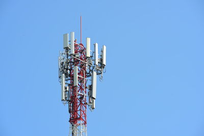 Low angle view of communications tower against clear blue sky