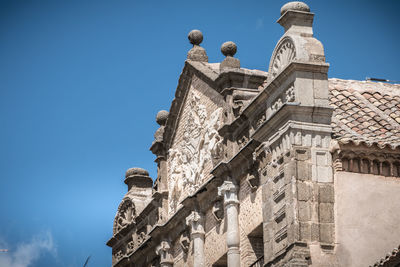 Low angle view of statues on building against sky