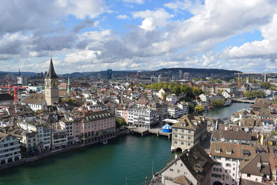 High angle view of river amidst buildings in city against sky