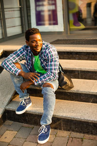 Portrait of young man sitting on staircase