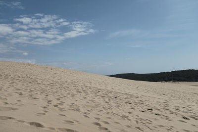 Sand dune on beach against sky