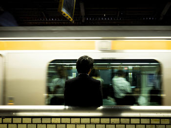 Passenger looking at blurred motion of train in subway