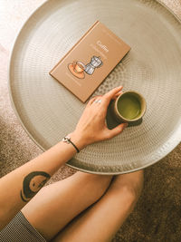 High angle view of woman holding coffee cup