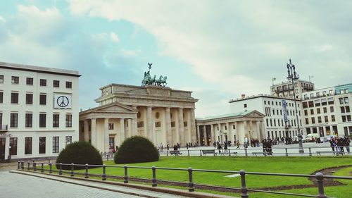 Buildings in city against cloudy sky