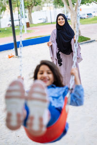 Mother with cheerful daughters enjoying at park