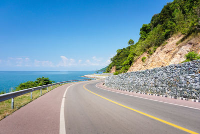 Surface level of empty road against calm sea