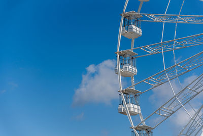 Low angle view of electricity pylon against blue sky