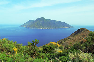 Scenic view of sea and mountains against sky