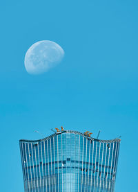 Low angle view of moon against blue sky