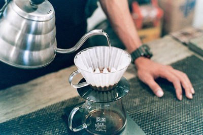 Midsection of man preparing drink in cafe