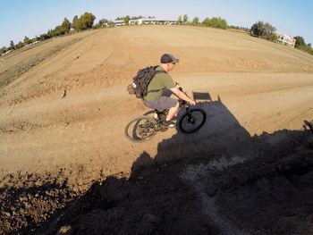 High angle view of man riding bicycle on dirt road