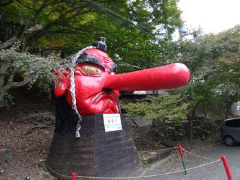 Red umbrella against trees