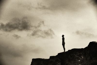 Low angle view of man standing on rock