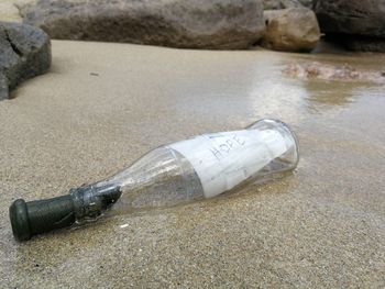 High angle view of bottle on rock at beach