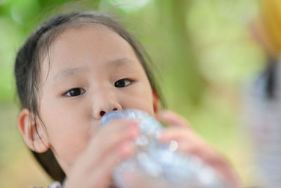 Close-up portrait of girl drinking water from bottle