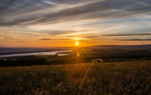 Scenic view of field against sky during sunset