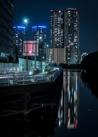 Illuminated buildings against sky at night