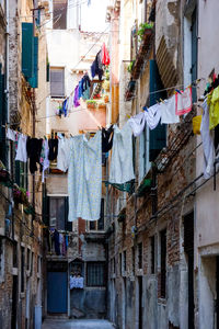 Low angle view of clotheslines hanging amidst buildings