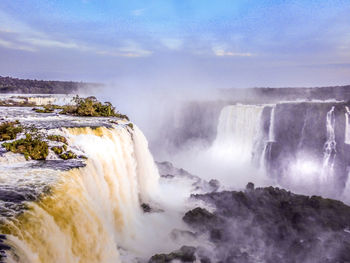 Scenic view of waterfall in sea against sky