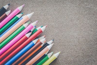Close-up of multi colored pencils on burlap