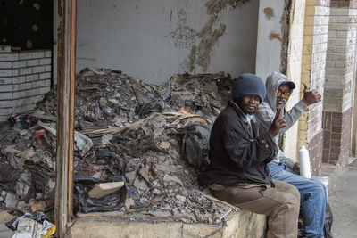 Man sitting in front of built structure