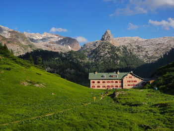 Scenic view of field by mountains against sky