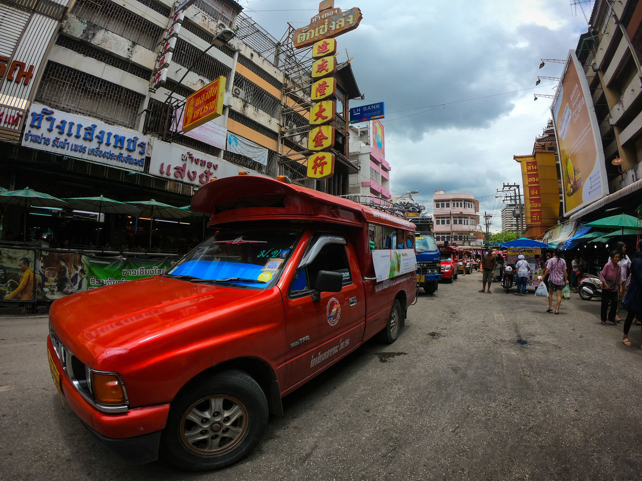 VEHICLES ON ROAD BY BUILDINGS AGAINST SKY