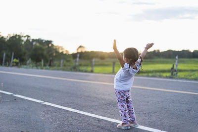 Rear view of woman walking on road