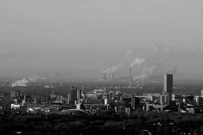 Smoke emitting from factory against clear sky