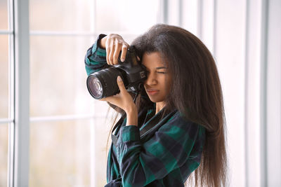 Young woman photographing with camera