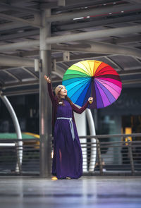 Woman holding multi colored umbrella