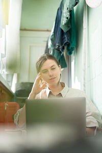 A young woman works remotely on laptop